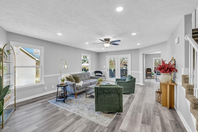 living room with a textured ceiling, ceiling fan, a healthy amount of sunlight, and light hardwood / wood-style floors