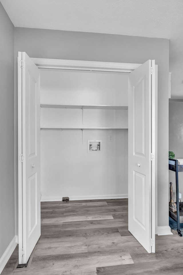 washroom featuring washer hookup and light hardwood / wood-style flooring