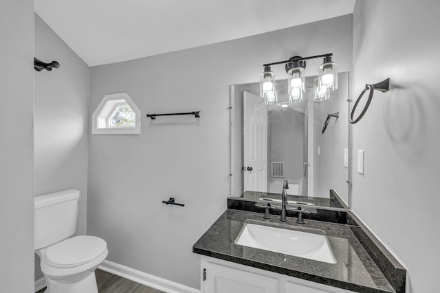 bathroom with toilet, hardwood / wood-style floors, and vanity