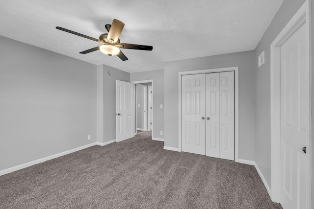 unfurnished bedroom with ceiling fan, carpet, a closet, and a textured ceiling