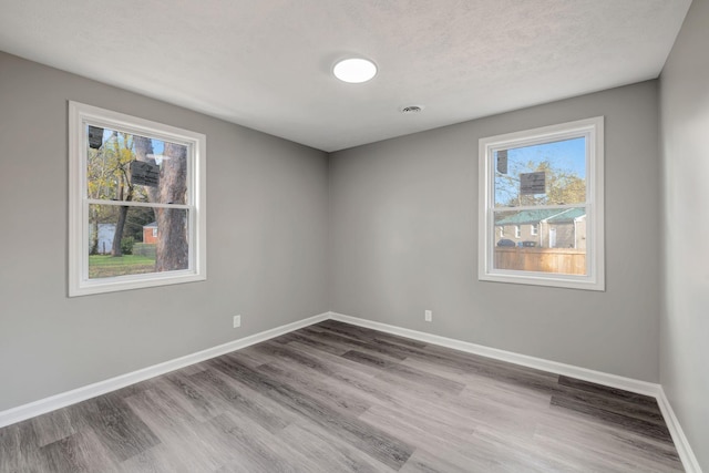 spare room featuring a textured ceiling and hardwood / wood-style floors