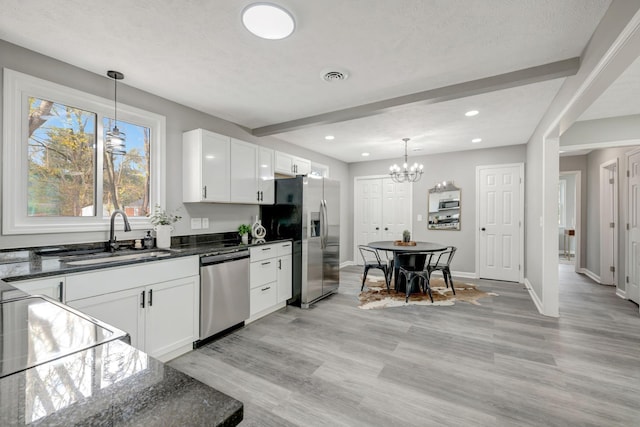 kitchen with decorative light fixtures, sink, white cabinets, and stainless steel appliances