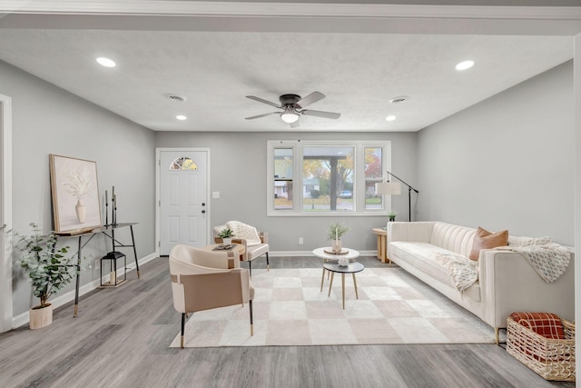 living room featuring ceiling fan and light hardwood / wood-style flooring