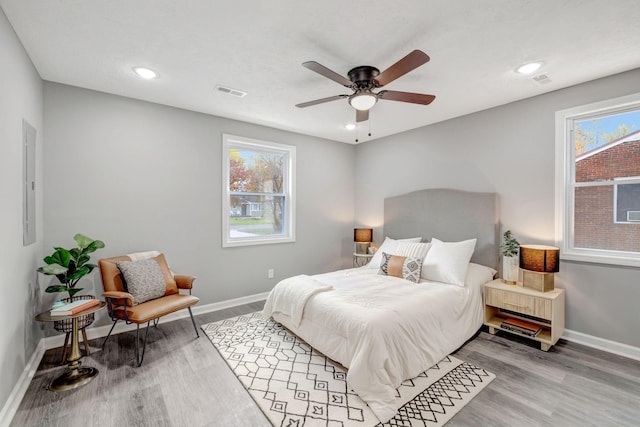 bedroom with ceiling fan, hardwood / wood-style flooring, and electric panel