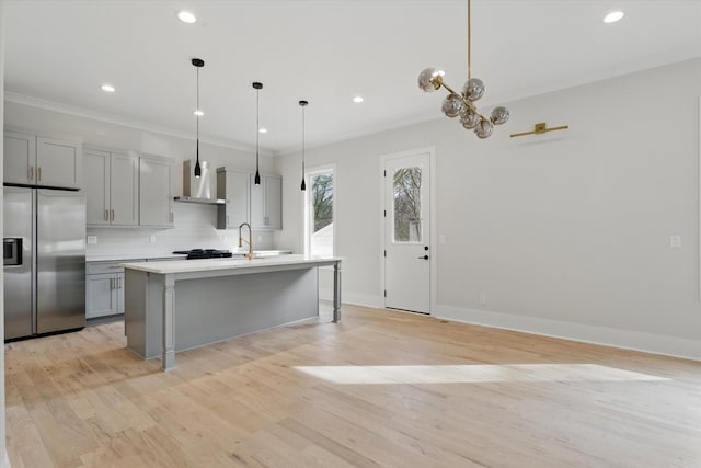 kitchen featuring ornamental molding, decorative backsplash, gray cabinets, stainless steel refrigerator with ice dispenser, and wall chimney exhaust hood