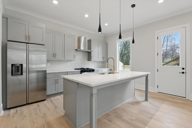 kitchen featuring wall chimney range hood, gray cabinets, stainless steel refrigerator with ice dispenser, stove, and a sink