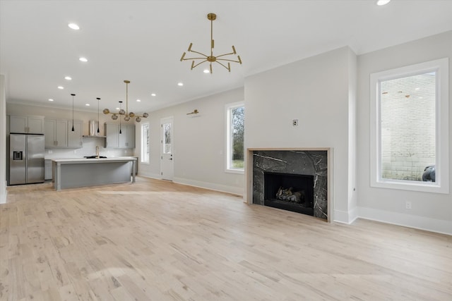 unfurnished living room with recessed lighting, baseboards, light wood-style flooring, and a fireplace