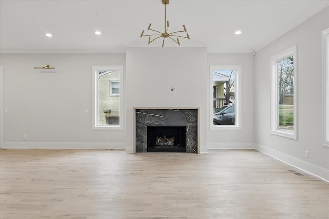 unfurnished living room featuring recessed lighting, baseboards, light wood-style floors, and a premium fireplace