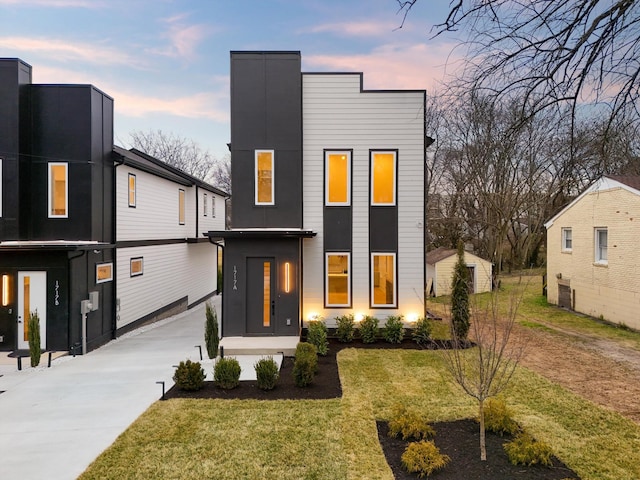 contemporary house featuring cooling unit, a lawn, and driveway