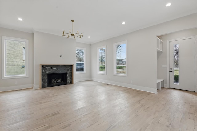 unfurnished living room with light wood finished floors, recessed lighting, a fireplace, and baseboards