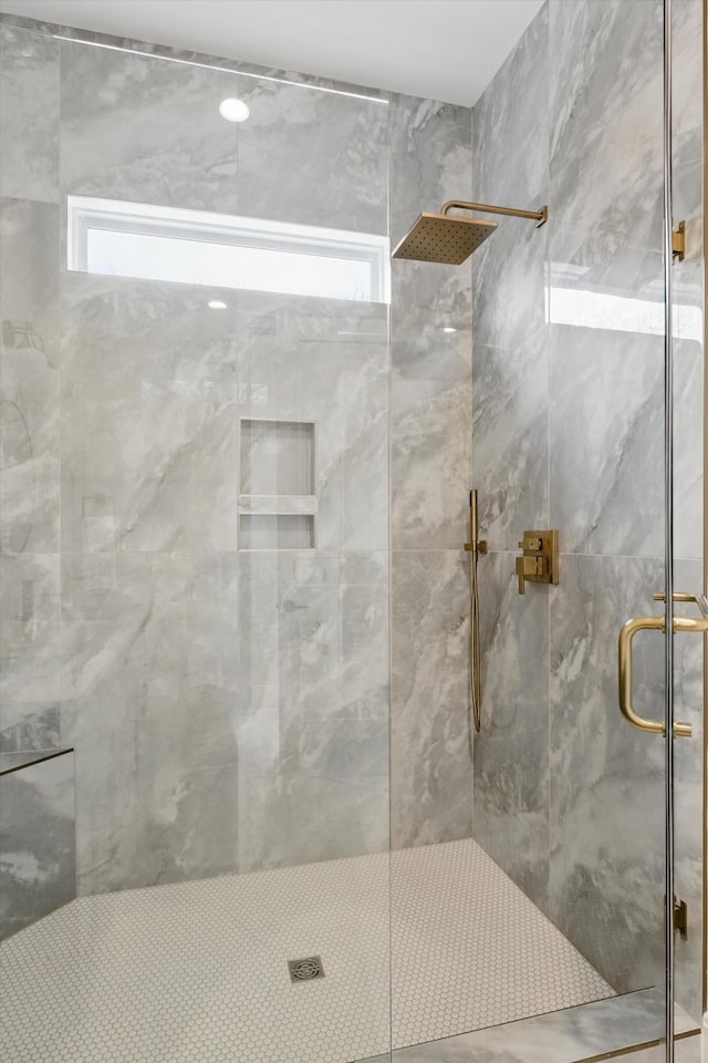 bathroom with a shower stall and plenty of natural light