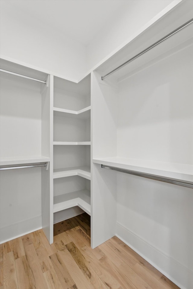 walk in closet with wood finished floors