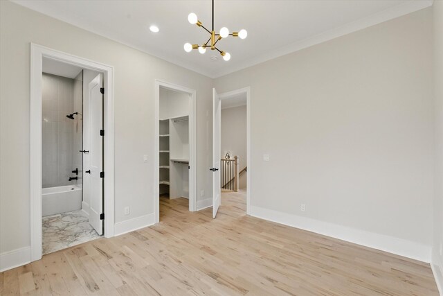 interior space with light wood finished floors, an inviting chandelier, baseboards, and ornamental molding