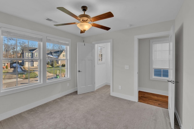 unfurnished bedroom with ceiling fan and light colored carpet