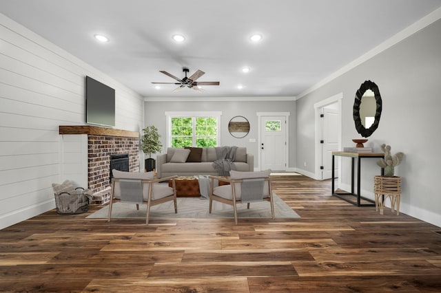 living room featuring ceiling fan, dark hardwood / wood-style flooring, a fireplace, and ornamental molding