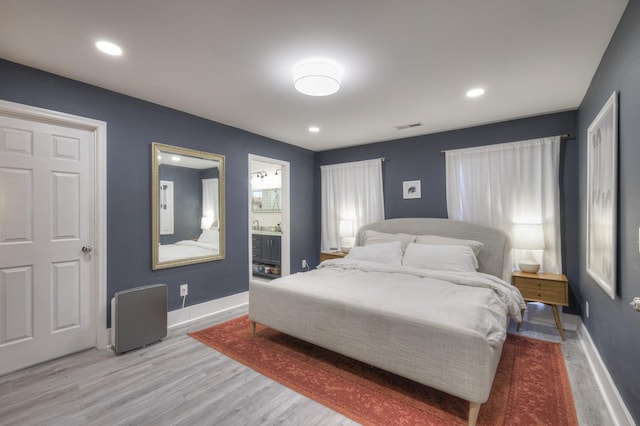 bedroom with wood-type flooring and ensuite bathroom