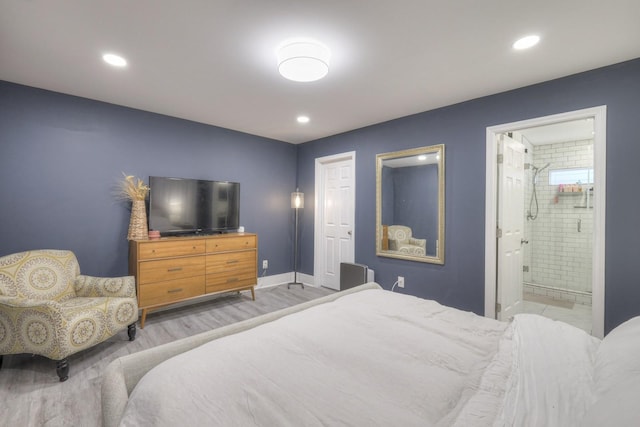 bedroom featuring connected bathroom and light hardwood / wood-style flooring