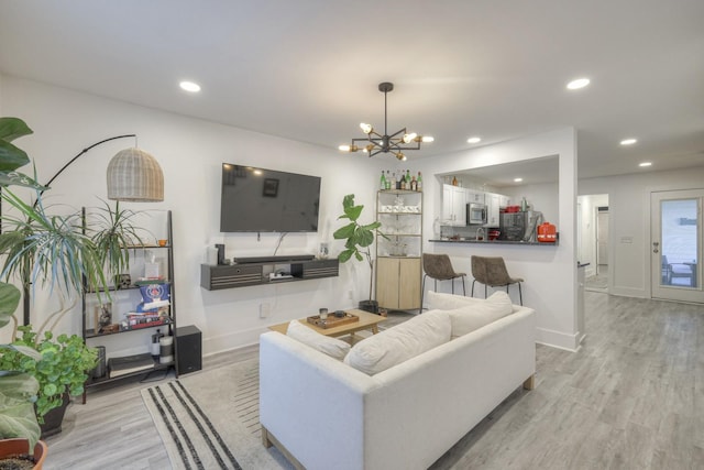 living room featuring light hardwood / wood-style flooring and a notable chandelier