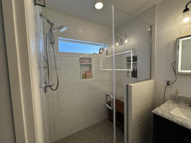 bathroom featuring tile patterned floors, an enclosed shower, and vanity