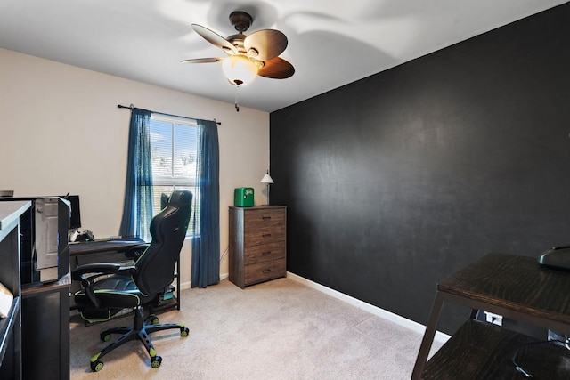 carpeted home office featuring baseboards and a ceiling fan