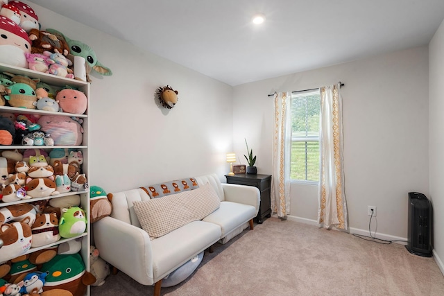 living area featuring carpet flooring and baseboards