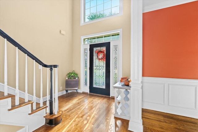 foyer entrance with crown molding and hardwood / wood-style flooring