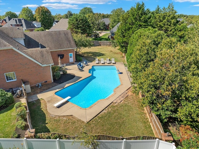 view of pool featuring a lawn, a diving board, and a patio area