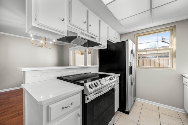 kitchen with light countertops, white cabinetry, stainless steel range with electric stovetop, under cabinet range hood, and baseboards