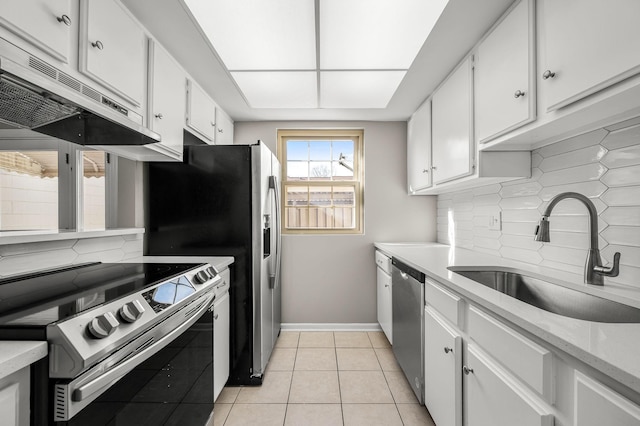 kitchen with light tile patterned floors, white cabinetry, stainless steel appliances, tasteful backsplash, and sink