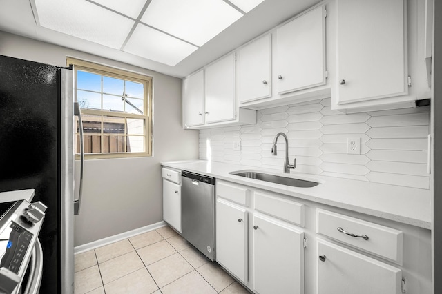 kitchen featuring light tile patterned floors, a sink, light countertops, appliances with stainless steel finishes, and decorative backsplash