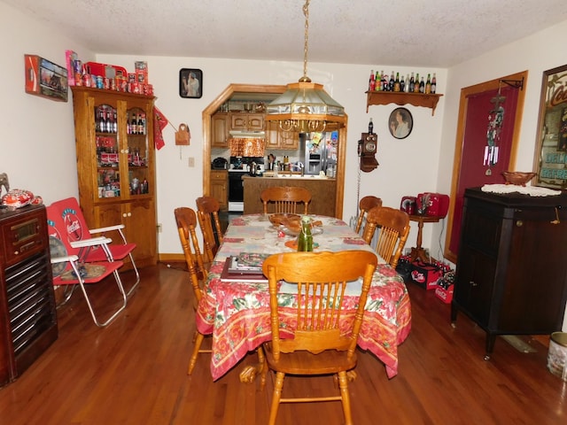 dining area with wood-type flooring and a textured ceiling