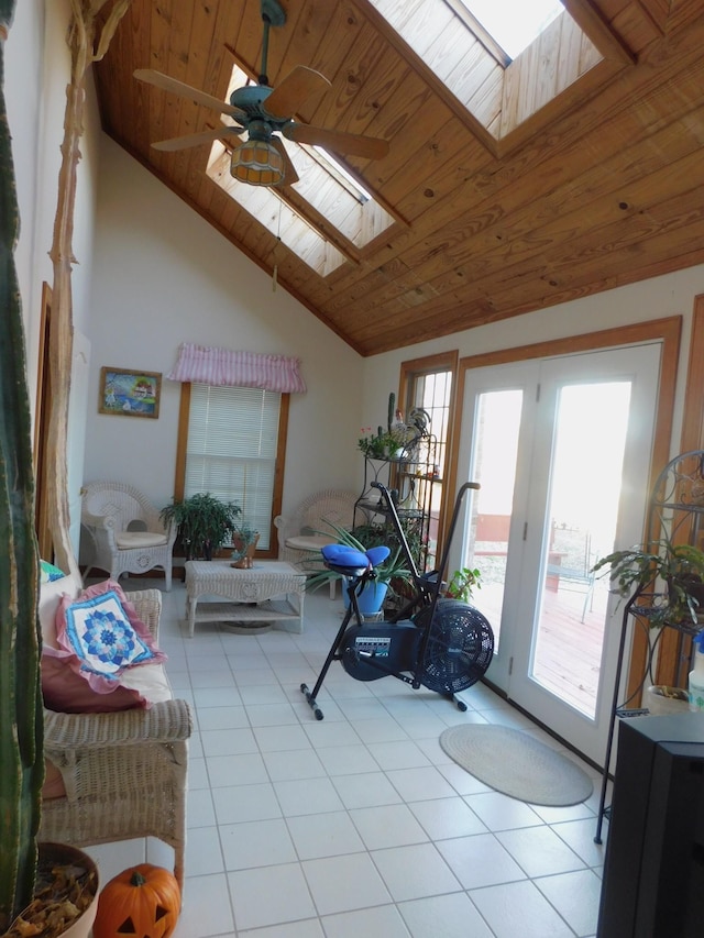 living room with wood ceiling, light tile patterned floors, ceiling fan, and lofted ceiling with skylight