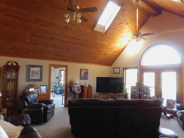 living room featuring wood ceiling, a skylight, ceiling fan, and carpet floors