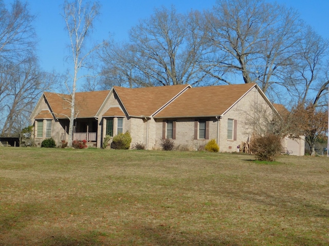 ranch-style home with covered porch and a front yard