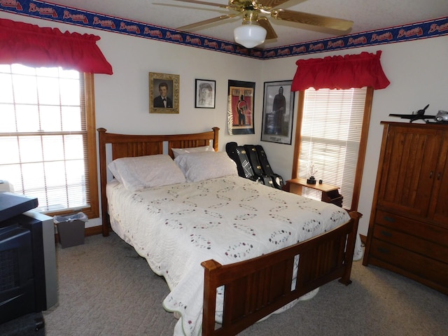 carpeted bedroom featuring ceiling fan and multiple windows