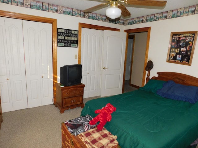 carpeted bedroom featuring two closets and ceiling fan