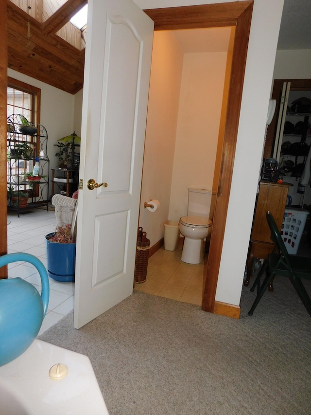 bathroom featuring toilet, wooden ceiling, and tile patterned flooring