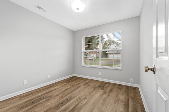 empty room featuring a textured ceiling and hardwood / wood-style floors