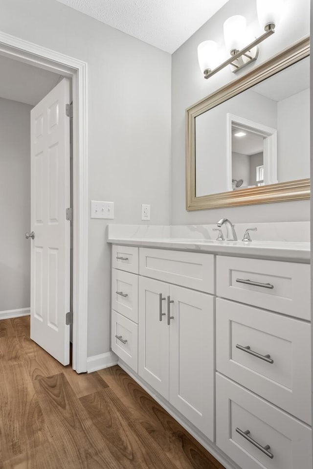 bathroom with vanity, wood-type flooring, and a textured ceiling