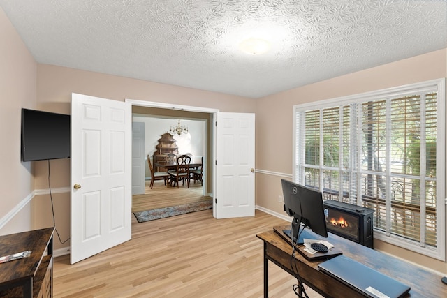 office area with a textured ceiling and light hardwood / wood-style flooring