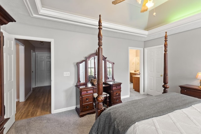 bedroom with connected bathroom, ceiling fan, light colored carpet, a tray ceiling, and crown molding