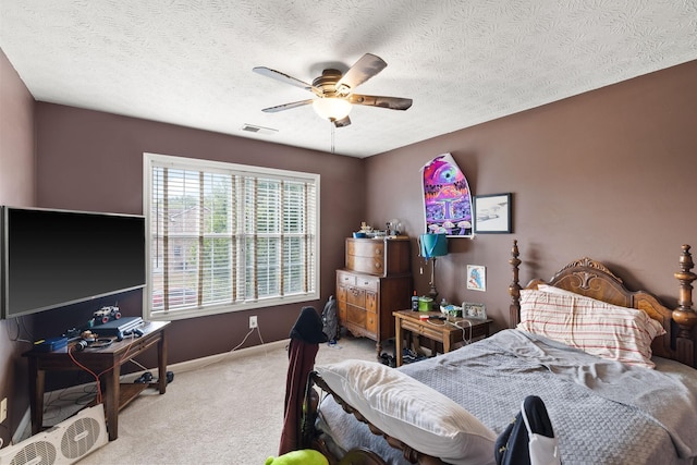 carpeted bedroom featuring ceiling fan and a textured ceiling