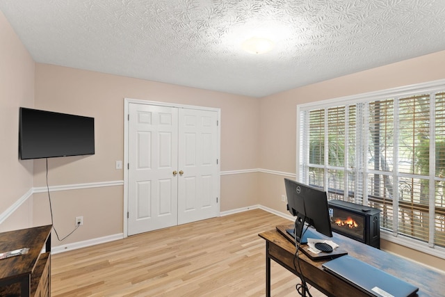 office space featuring a textured ceiling and light hardwood / wood-style floors