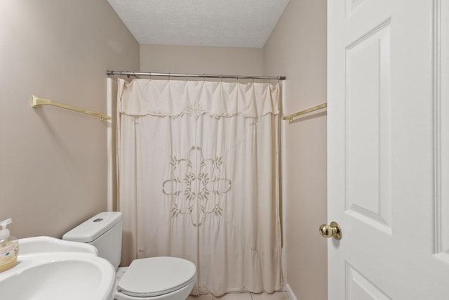 bathroom featuring toilet, sink, a textured ceiling, and curtained shower