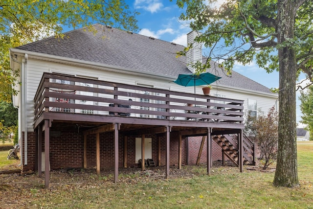 rear view of property featuring a lawn and a deck