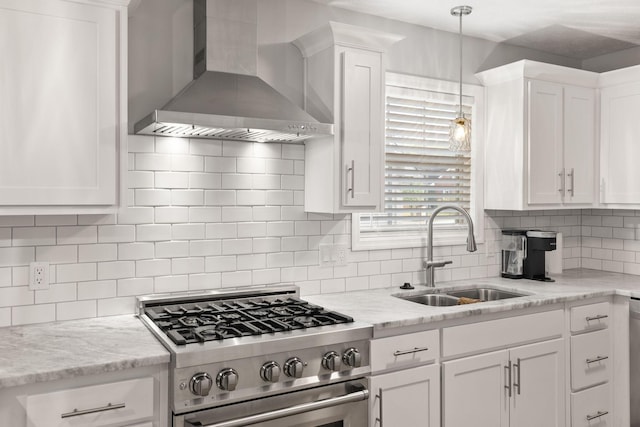 kitchen featuring stainless steel appliances, decorative backsplash, wall chimney range hood, white cabinets, and sink