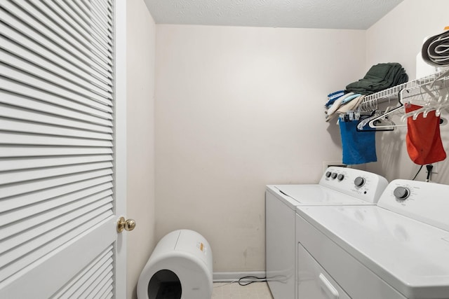 laundry room with separate washer and dryer and a textured ceiling