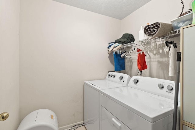 laundry room with a textured ceiling and washing machine and clothes dryer