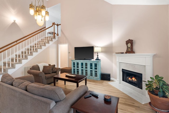 living room with a fireplace, a chandelier, and hardwood / wood-style flooring