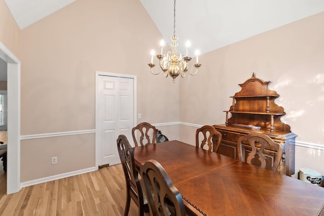 dining room featuring a chandelier, light hardwood / wood-style floors, and high vaulted ceiling